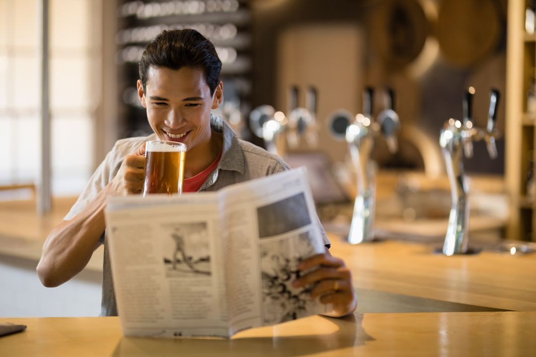Man having beer while reading newspaper in a restaurant - Free Images, Stock Photos and Pictures on Pikwizard.com