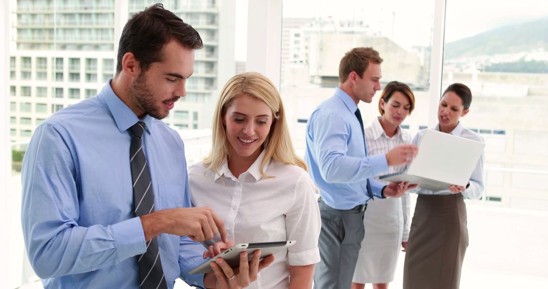 Professional Business Team Collaborating on Tablet in Modern Office