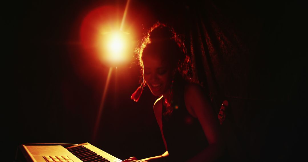 Female Musician Performing on Keyboard Under Dramatic Stage Lighting - Free Images, Stock Photos and Pictures on Pikwizard.com