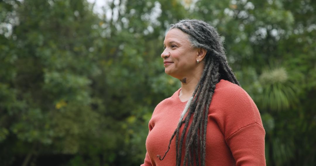 Senior Woman with Dreadlocks Enjoying Tranquil Garden