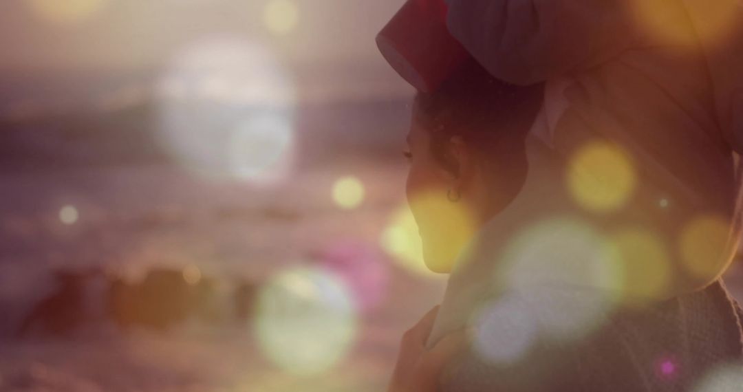 Woman with Turban Overlooking Sunset Sea with Bokeh Effects