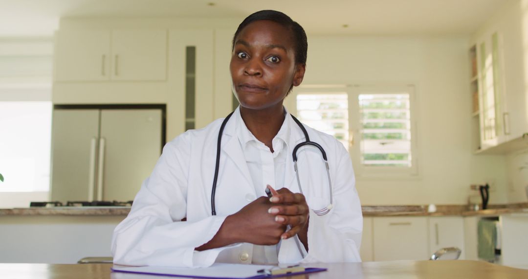 Confident African Female Doctor Sitting at Desk in Modern Clinic - Free Images, Stock Photos and Pictures on Pikwizard.com