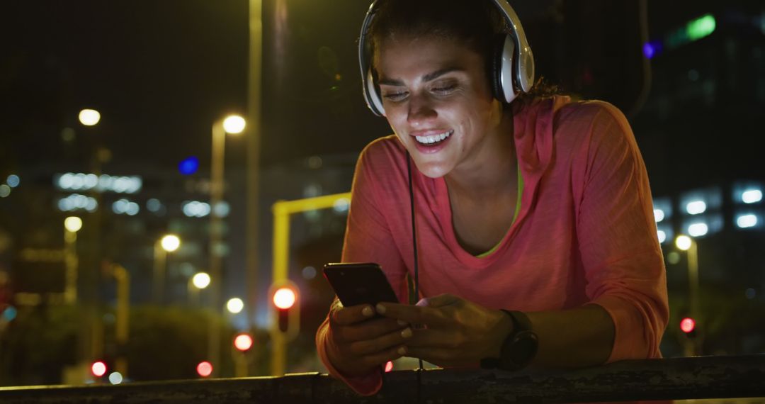 Woman Listening to Music on Smartphone at Night Outdoors - Free Images, Stock Photos and Pictures on Pikwizard.com