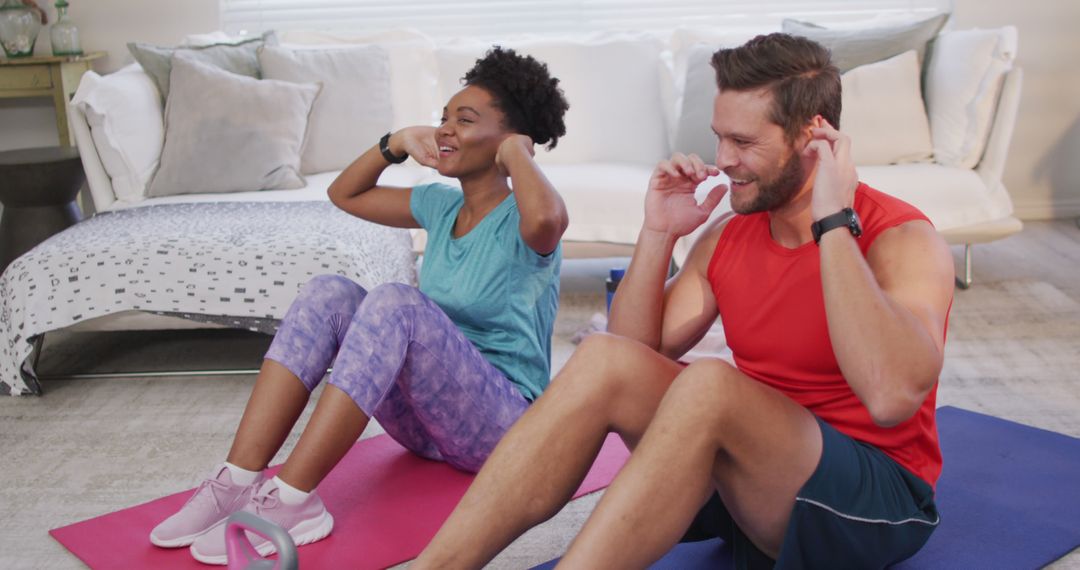 Image of happy diverse couple training together at home, doing sit ups - Free Images, Stock Photos and Pictures on Pikwizard.com