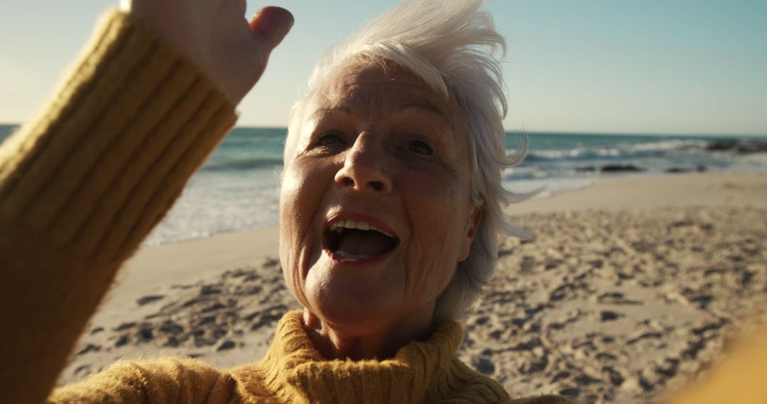 Cheerful Senior Woman Enjoying Sunny Beach Day - Free Images, Stock Photos and Pictures on Pikwizard.com