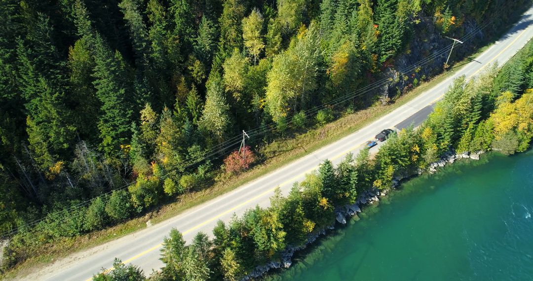 Aerial View of Forest-lined Road by Serene Lake - Free Images, Stock Photos and Pictures on Pikwizard.com