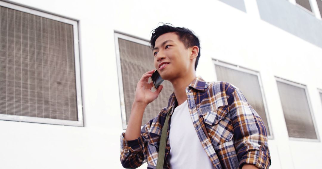 Young Guy Wearing Plaid Shirt, Talking on Phone Outdoors - Free Images, Stock Photos and Pictures on Pikwizard.com