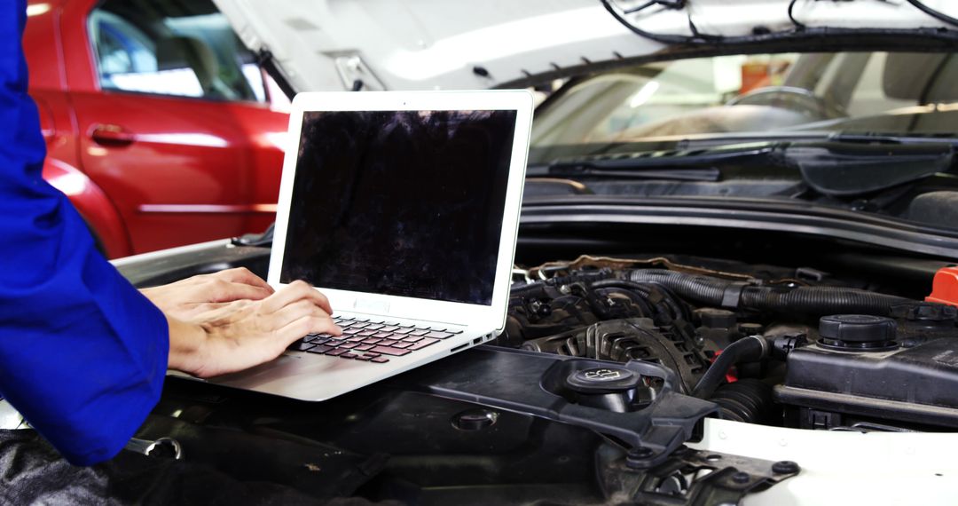 Mechanic Using Laptop for Vehicle Engine Diagnostics in Auto Repair Shop - Free Images, Stock Photos and Pictures on Pikwizard.com