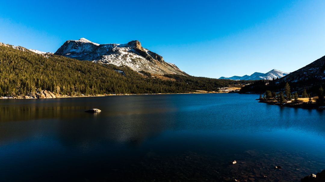 Serene Mountain Lake with Snow-Capped Peaks under Clear Blue Sky - Free Images, Stock Photos and Pictures on Pikwizard.com
