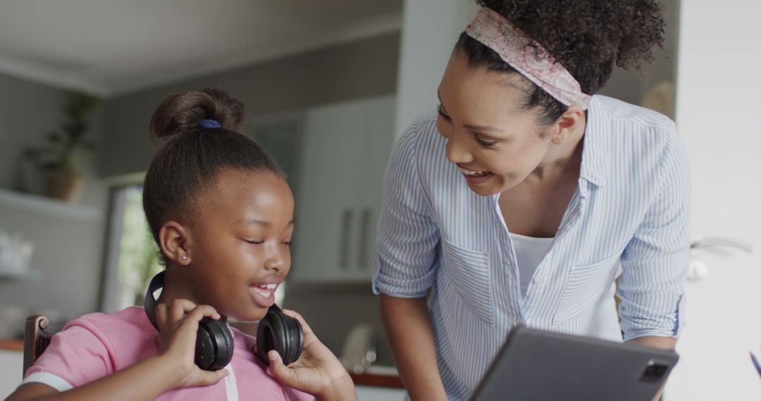 African American Mother Helping Daughter with Studies in Kitchen - Free Images, Stock Photos and Pictures on Pikwizard.com