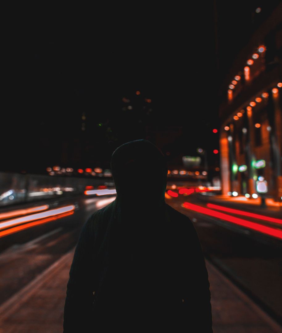 Silhouette of Person Standing on City Street at Night with Light Trails - Free Images, Stock Photos and Pictures on Pikwizard.com