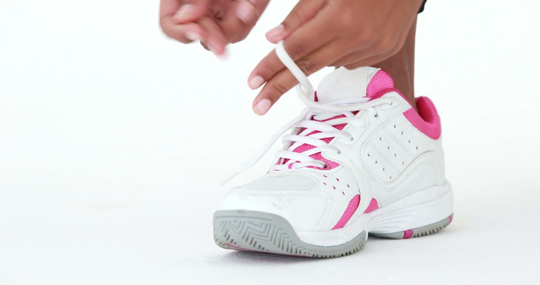 Person Tying White and Pink Sports Shoes on White Background - Free Images, Stock Photos and Pictures on Pikwizard.com