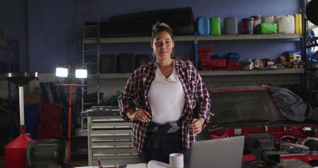 Smiling Female Mechanic in Garage Workshop Wearing Plaid Shirt - Free Images, Stock Photos and Pictures on Pikwizard.com