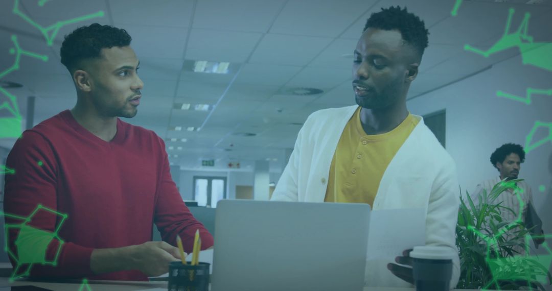 Colleagues Collaborating at Office Desk with Laptop and Documents