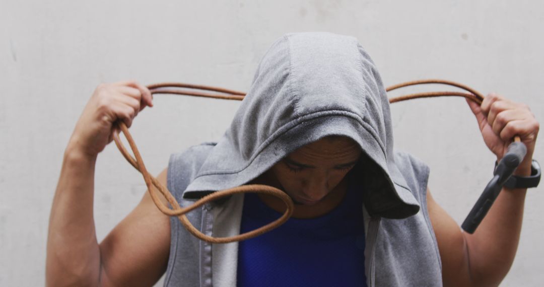 Man in Hoodie Holding Jump Rope Focused on Workout Preparation - Free Images, Stock Photos and Pictures on Pikwizard.com