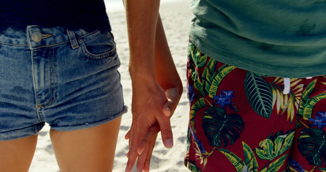 Close-up of a young Caucasian man and young Biracial woman holding hands at the beach - Free Images, Stock Photos and Pictures on Pikwizard.com