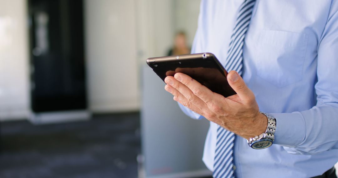 Businessman Holding Tablet in Modern Office Setting - Free Images, Stock Photos and Pictures on Pikwizard.com