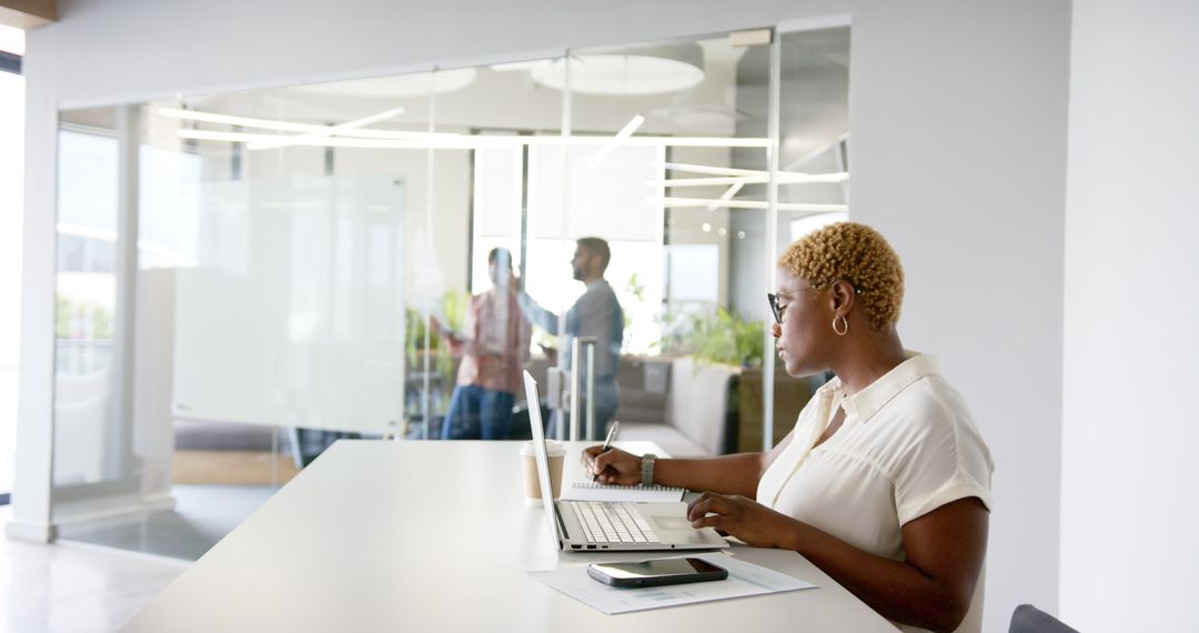 Focused Professional Working in Modern Office with Glass Panels