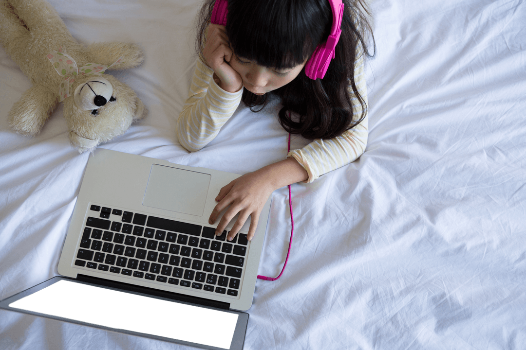 Young Girl with Headphones Using Laptop on Transparent White Bed