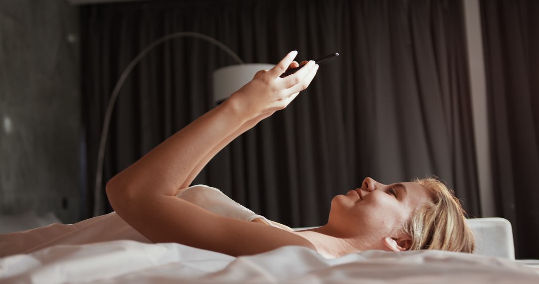 Woman Relaxing in Bed and Using Smartphone - Free Images, Stock Photos and Pictures on Pikwizard.com