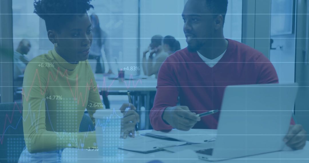 Focused Colleagues Collaborating with Laptop in Modern Open-Plan Office