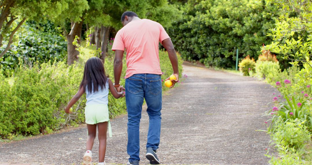 Father and Daughter Strolling on Garden Path Under Sunlight