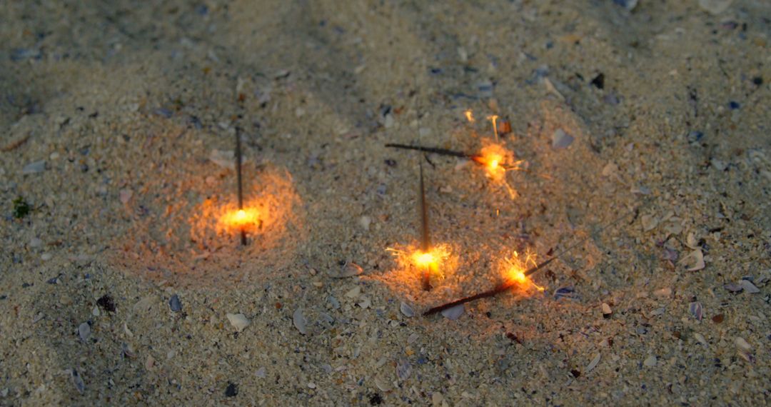 Sparklers Stuck in Sand on Beach Creating Playful Glow - Free Images, Stock Photos and Pictures on Pikwizard.com