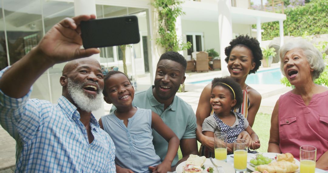 Happy Multigenerational Family Enjoying Breakfast and Taking Selfie in Garden