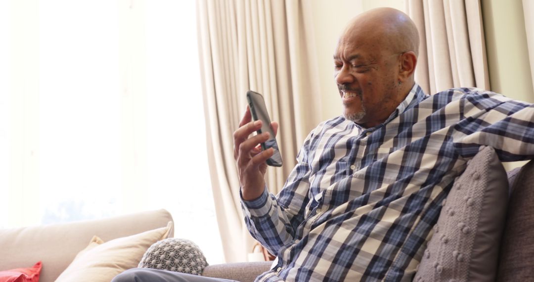 Senior Man Smiling While Video Calling on Smartphone at Home - Free Images, Stock Photos and Pictures on Pikwizard.com