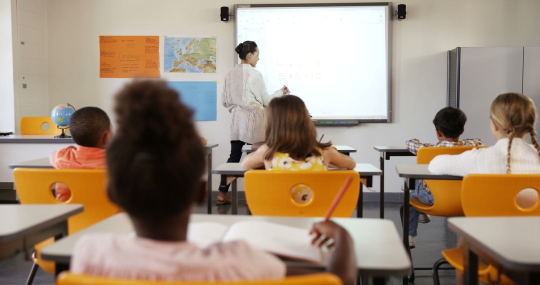 Teacher Uses Interactive Whiteboard in Diverse Elementary Classroom - Free Images, Stock Photos and Pictures on Pikwizard.com