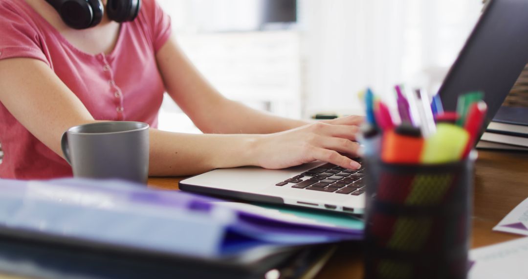 Caucasian Woman Working at Home Desk with Laptop and Smartphone