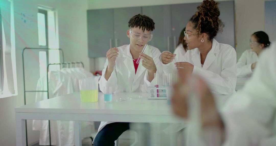 Students collaborating in school science lab conducting colorful chemistry experiments with test tub