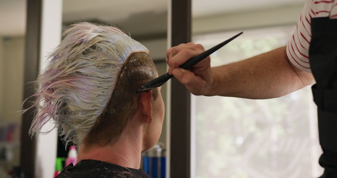 Hairdresser applying hair dye to client with modern haircut in salon - Free Images, Stock Photos and Pictures on Pikwizard.com