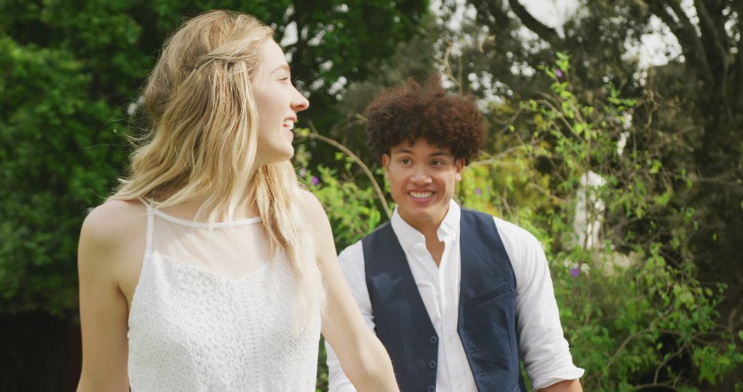 Joyful Diverse Couple Walking Together at Outdoor Wedding Celebration