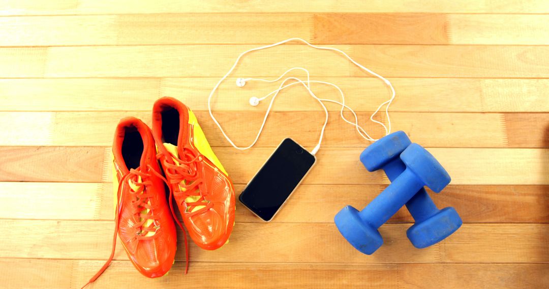 Sports Shoes with Dumbbells and Smartphone on Wooden Floor - Free Images, Stock Photos and Pictures on Pikwizard.com