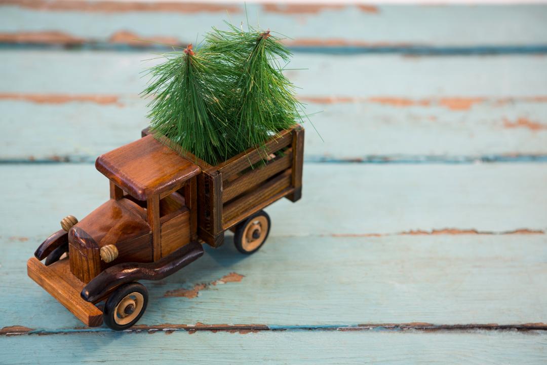 Vintage Toy Truck Carrying Christmas Tree on Rustic Wooden Plank - Free Images, Stock Photos and Pictures on Pikwizard.com
