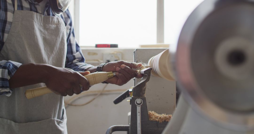 Carpenter Woodturning on Lathe in Workshop