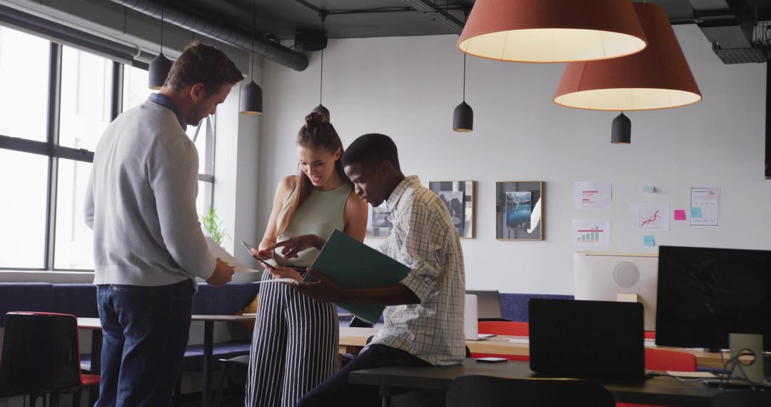 Coworkers Collaborating with Binder and Tablet in Modern Office