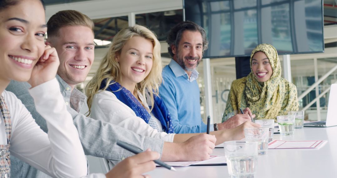 Diverse Team Smiling in Bright Office During Collaborative Meeting