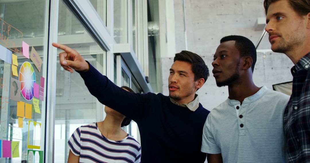Young Professionals Brainstorming Around Office Whiteboard