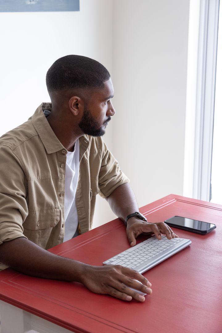 Focused Professional Using Keyboard by Window