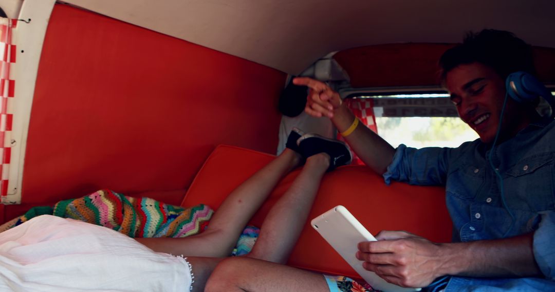 Young Man and Woman Relaxing in Camper Van, Listening to Music - Free Images, Stock Photos and Pictures on Pikwizard.com