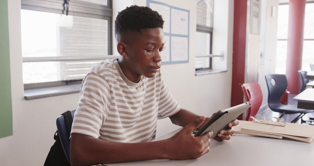 African American Student Reading Tablet in Classroom Setting