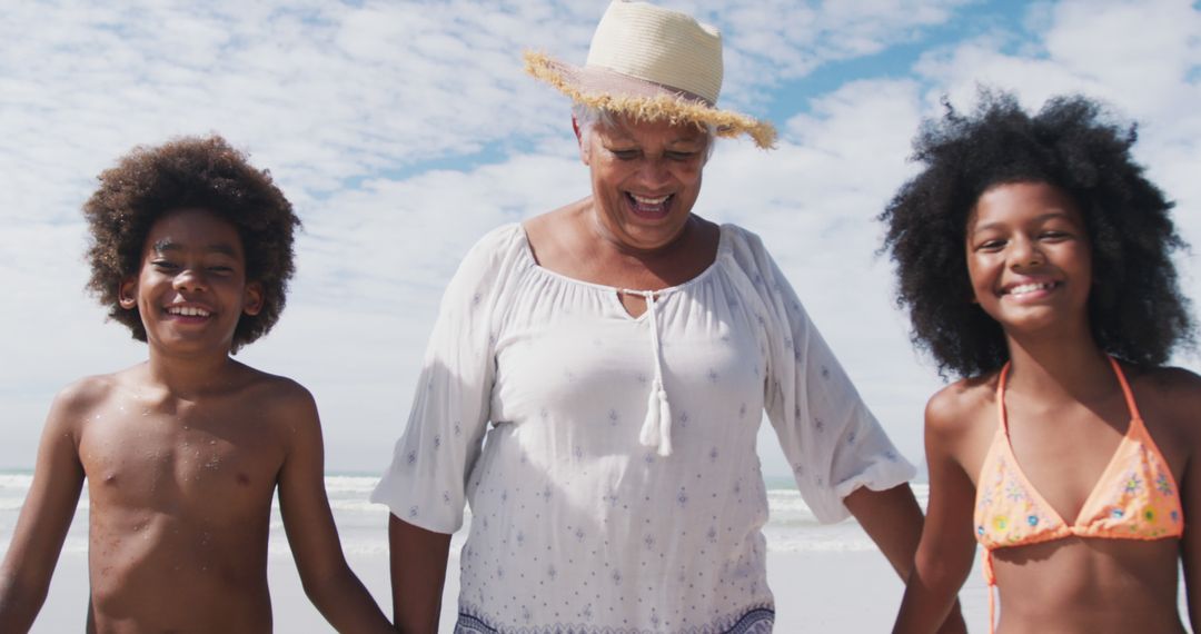 Senior Woman Enjoying Beach Day with Grandchildren on Sunny Day - Free Images, Stock Photos and Pictures on Pikwizard.com