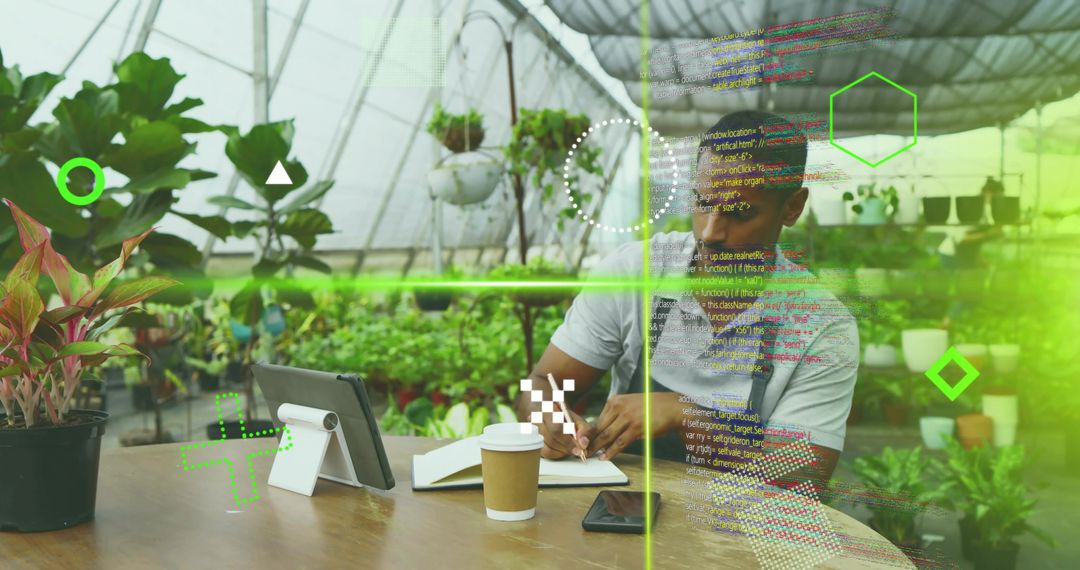 African American man researching and writing in greenhouse using tablet with green tech overlay