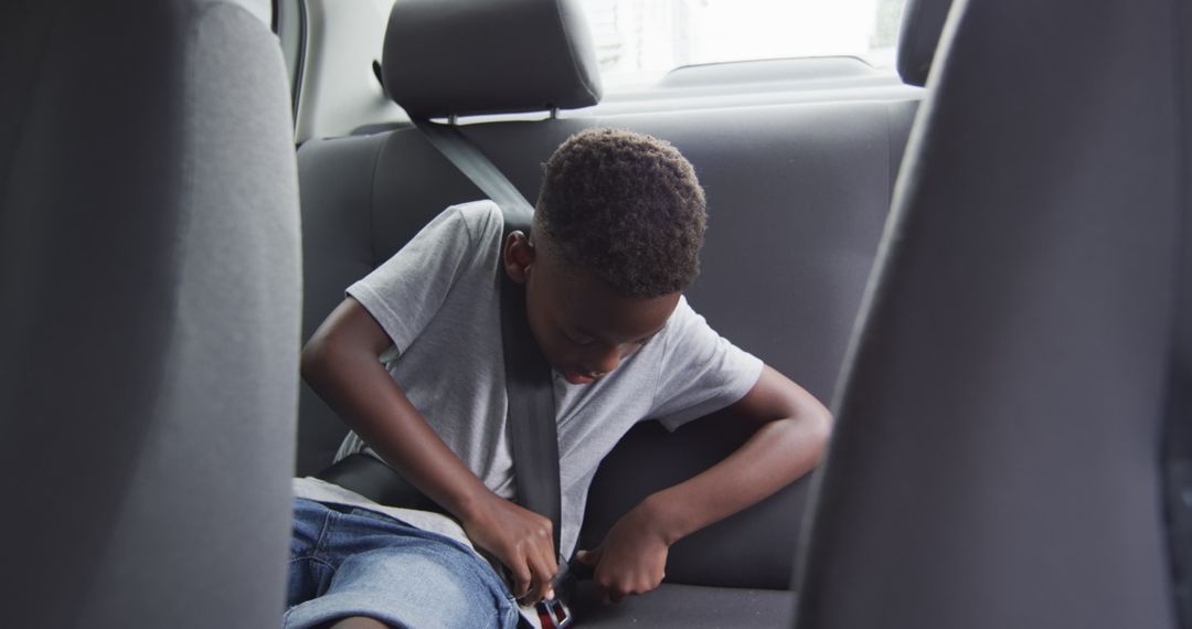 Young Boy Buckling Seatbelt in Backseat for Safety