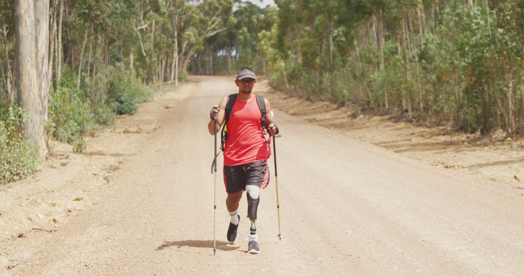 Amputee Athlete Running on Forest Path with Hiking Poles - Free Images, Stock Photos and Pictures on Pikwizard.com