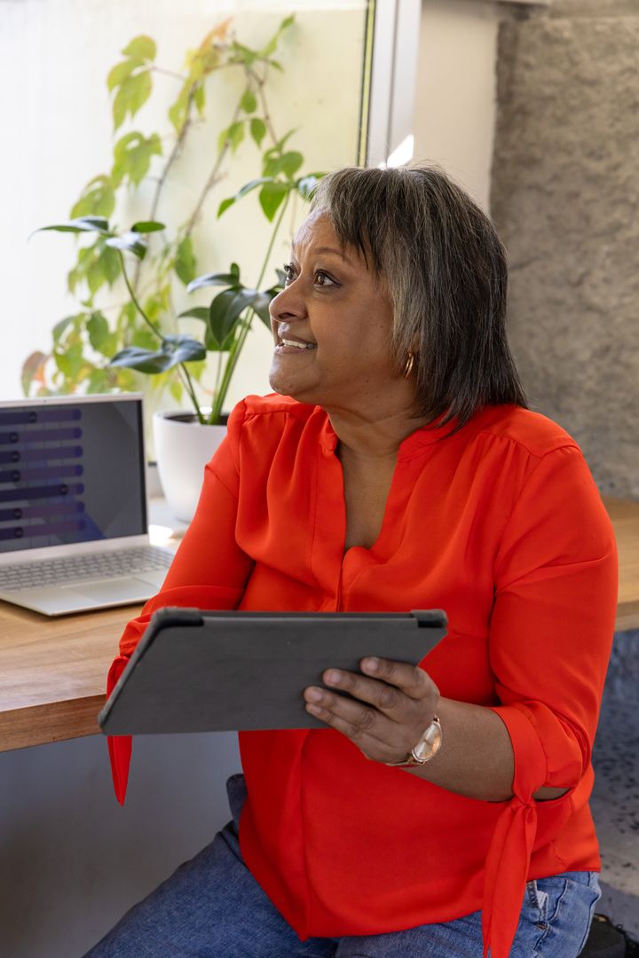 Senior Woman Using Tablet in Modern Office Setting