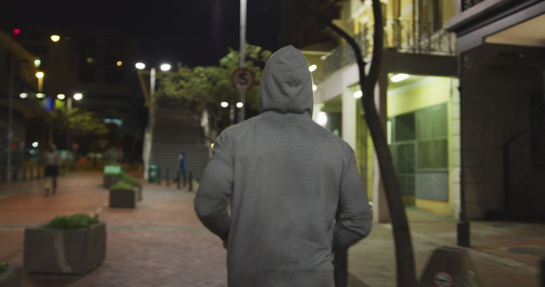 Person Walking Alone on City Street at Night in Hoodie - Free Images, Stock Photos and Pictures on Pikwizard.com