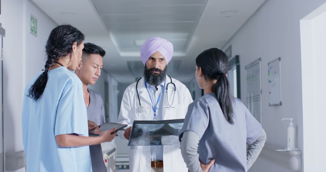 Diverse Medical Team Discussing Patient X-Ray in Hospital Corridor - Free Images, Stock Photos and Pictures on Pikwizard.com